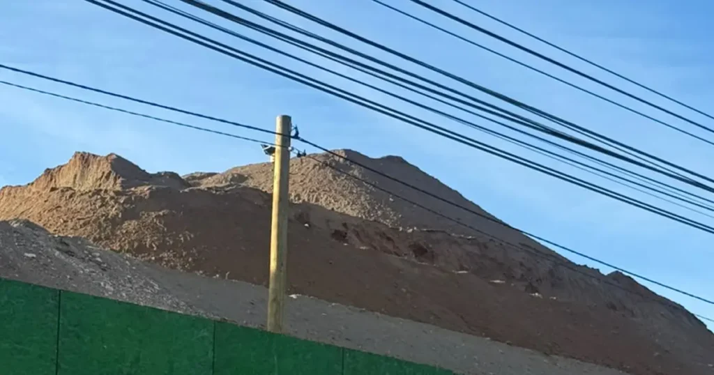 Gran montículo de tierra se observa detrás del cierre perimetral verde en las obras del Hospital de Illapel.
